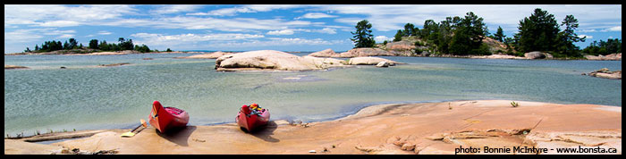 Kayaks on the pink granite shorelines of Philip Edward Island Killarney Ontario